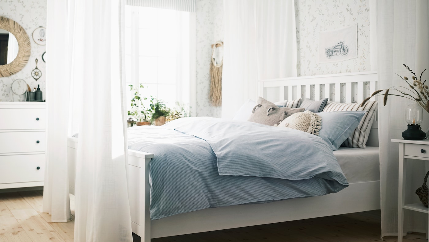 В этой белой спальне большой каркас кровати в классическом стиле окружен белыми шторами. В сочетании с другими предметами мебели она создает современную, но в то же время романтическую обстановку, отражающую индивидуальность того, кто пользуется этой комнатой.